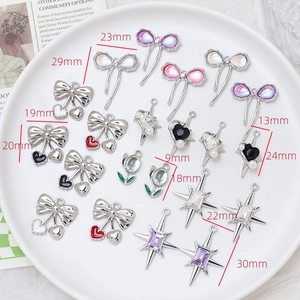 Detailed view of DIY alloy charms with zircon inlays and dimensions on white plate