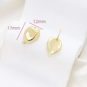 Macro view of gold-plated baroque style earring base with hammered texture and loop