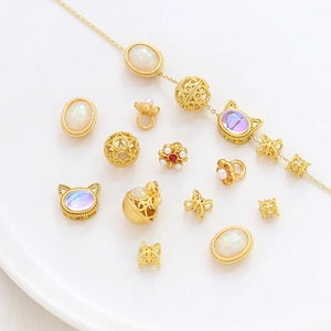 Set de joyería DIY dorada con piedras de opalo, perlas y colgantes en plato cerámico