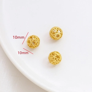 Detalle de tres cuentas de filigrana doradas de 10 mm para creación de joyas DIY