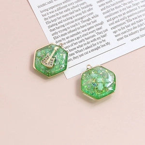 Dettaglio macro di ciondoli a chitarra in cristallo verde con lamina d'oro e glitter