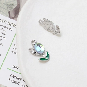 Detail of silver tulip charms with iridescent inlay and green enamel for DIY jewelry