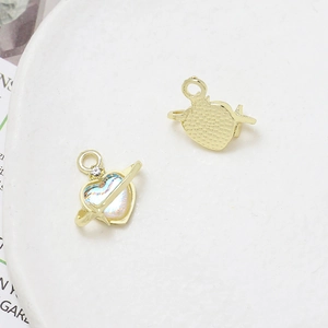 Detailed macro view showing the heart-shaped Saturn charm with iridescent center in gold