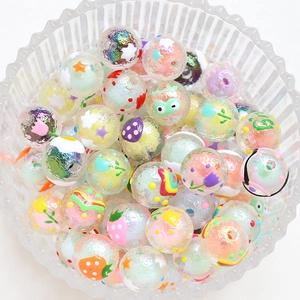 Hand-painted glass beads with strawberry and flower patterns in a glass bowl