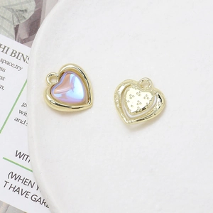Detailed view of iridescent heart-shaped charms with golden textured back for jewelry DIY