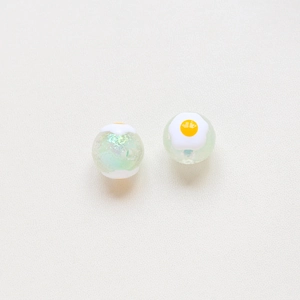 Close-up of translucent aurora beads and creative fried egg resin charms for DIY jewelry