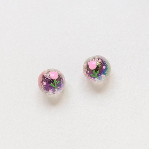 Detail of hand-painted purple iris glass beads featuring pink tulip floral patterns