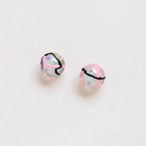 Macro shot of two translucent tulip glass beads with hand-painted patterns and iridescent foil