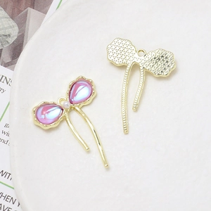 Detail of pink pearlescent bow pendant in gold setting with front and back view