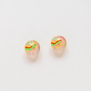 Macro detail of handmade pink translucent sphere earrings with colorful painted patterns