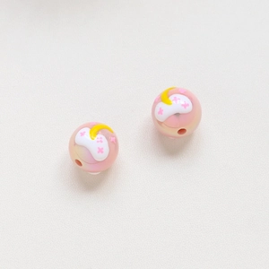 Vista dettagliata di perle iridescenti rosa da 16 mm con motivi di stelle e luna DIY