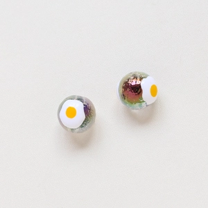 Macro shot of two creative fried egg pattern iridescent glass beads for DIY jewelry making