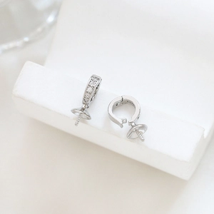 Close-up of silver-plated DIY earring findings with cubic zirconia inlay and pearl pegs
