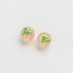 Close-up of pink translucent tulip glass beads with yellow polka dots for DIY jewelry