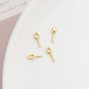 Macro shot of 4 gold-plated pear-shaped bead cups with screw pins for DIY jewelry making