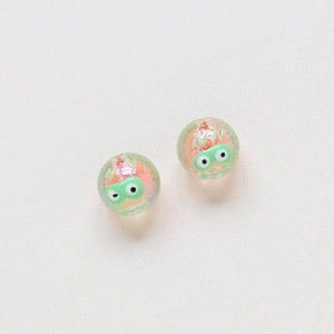 Macro shot of transparent tulip beads with cartoon monster faces for DIY jewelry making