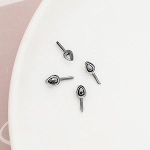 Macro shot of gunmetal teardrop jewelry bases with needle pins for DIY handmade crafts