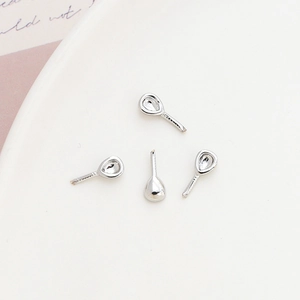 Polished silver teardrop earring studs and DIY jewelry components on a clean white tray