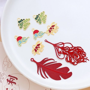 Macro view of assorted Chinese-style alloy charms featuring clouds, feathers and pine trees