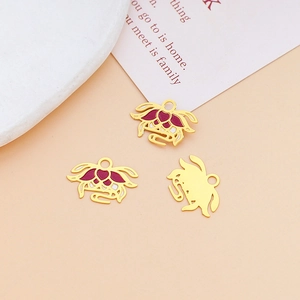 Detailed view of red enamel lotus charms in gold finish for DIY jewelry making