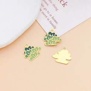 Macro view showing green pine tree alloy charms with golden finish for jewelry making