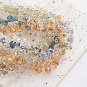 Facettierte Glastropfen-Perlen in verschiedenen Farben für DIY-Schmuck auf Steinuntergrund