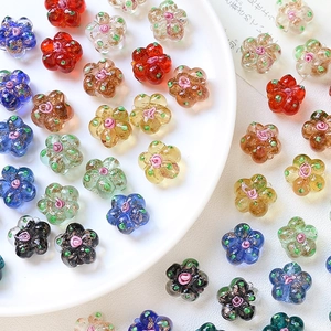 Macro shot of colorful glass flower beads with glitter details for DIY jewelry making