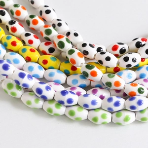 Macro shot of oval ceramic beads with colorful polka dot patterns for DIY jewelry making