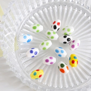 Detailed view of colorful polka dot oval ceramic beads for DIY jewelry making