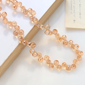 Nahaufnahme von facettierten champagnerfarbenen Glastropfenperlen für DIY-Schmuck
