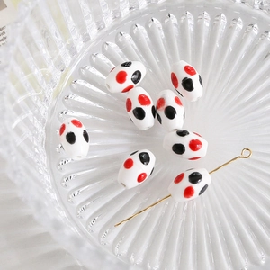 Close-up of red and black polka dot oval ceramic beads for DIY jewelry making