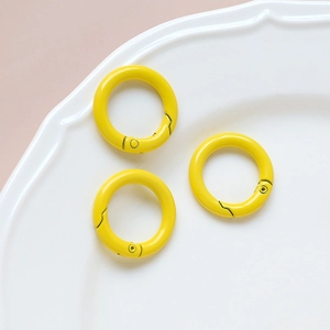 Three bright yellow round spring O-rings for DIY keychains and jewelry accessories