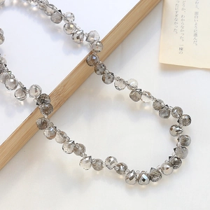 Makro-Detail von facettierten grauen Glastropfenperlen für DIY-Schmuck und Bastelprojekte