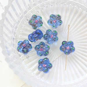 Macro shot of blue handmade glass flower beads with glitter detail for DIY jewelry