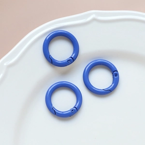 Detailed view of three bright blue macaron spring O-rings on a white ceramic tray