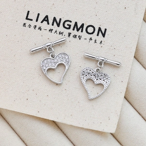 Detail of heart-shaped zircon earrings with silver metal T-bar design on canvas