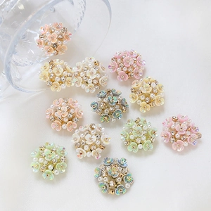 Macro shot of colorful resin flower charms with pearls and rhinestones for DIY jewelry making