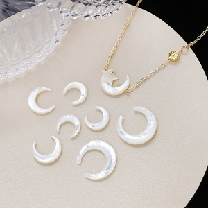 Natural white mother of pearl moon pendants with gold star necklace on beige board