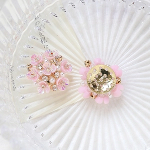 Macro detail of pink flower jewelry parts with white pearls and sparkling crystals