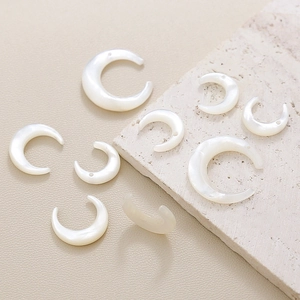 Macro detail of crescent moon white shell pendants with natural iridescent pearl luster