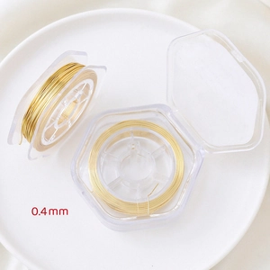 Detail of 0.4mm gold-plated copper wire on hexagonal spools for DIY jewelry making