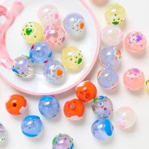 Close-up of colorful DIY hand-painted acrylic round beads with cat paw and heart patterns