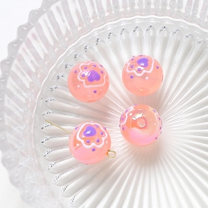 Detailed view of pink resin beads with purple cat paw and heart patterns for DIY jewelry