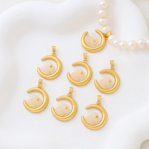 Golden moon pendants with jade rabbit inlays shown on white pearl necklace