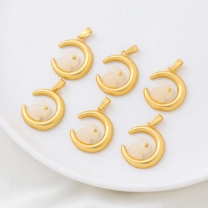 Golden moon and white rabbit pendants arranged on a ceramic plate for DIY jewelry making