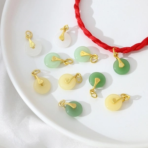 Detailed view of mini jade pendant charms with gold fan-shaped buckles for jewelry DIY