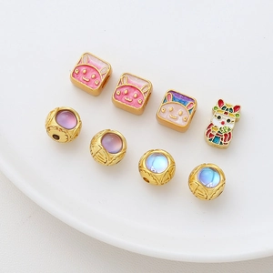 Macro shot of gold-plated rabbit enamel beads and ornate hollow charms for DIY jewelry