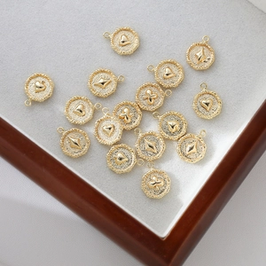 Vista de detalle de dijes de corazón y picas bañados en oro 18k en bandeja de joyería