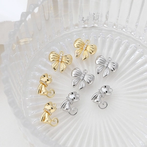 Detailansicht der gold- und silbernen Katzen- und Bogenanhänger mit Strass für DIY-Schmuck