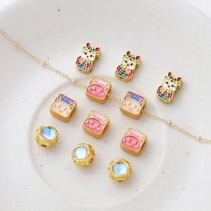 Macro shot of gold-plated lion dance and rabbit enamel beads for DIY jewelry making